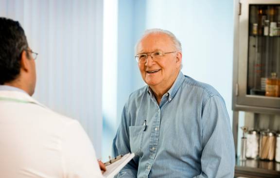 Arzt spricht mit älterem Patienten