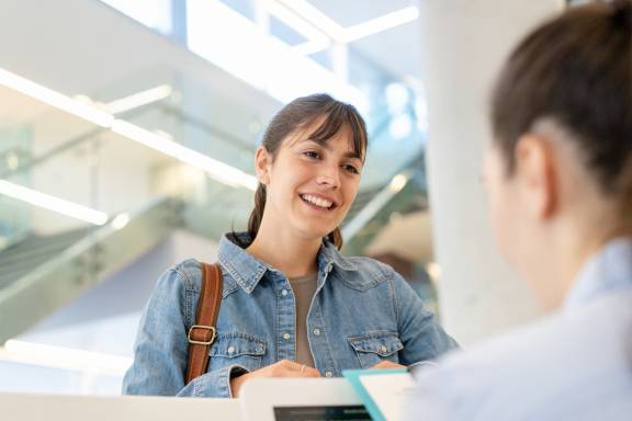 Frau spricht mit MFA am Empfang